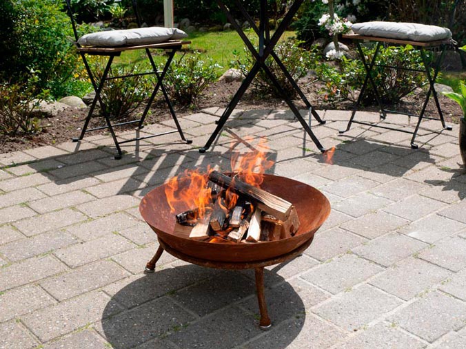 Ogród z przytulnymi dodatkami i nastrojowym paleniskiem na świeżym powietrzu.